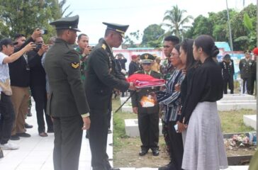 Danrem 173 PVB Brigjen TNI Franz Yohanes Purba menyerahkan bendera merah putih kepada istri almarhum Lettu Inf (Anm) Ocktavianus Sogalrey didampingi ketiga anaknya