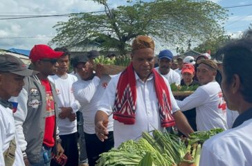 Cawagub Yermias Bisai menerima hasil bumi warga Koya sebelum menggelar acara tatap muka bersama warga