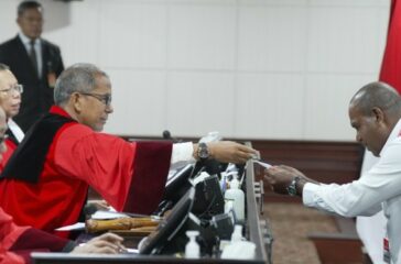 Pihak terkait Prinsipal Yermias Bisa isaat menyerahkan KTP kepada Majelis Hakim MK yang diketuai Saldi Isra. Yermias hadir di persidangan terkait masalah Suket Palsu