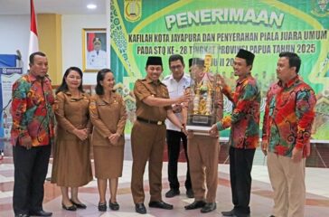 Wakil Walikota Jayapura Rustan Saru saat menerima Piala Bergilir dari Manager Tim STQ Kota Jayapura